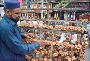 A roadside vendor displays handcrafted wooden keychains, each featuring with names and alphabets, unique blend of artistry and charm in the provincial capital.