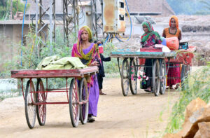 Gypsy women on the way pushing the handcarts at Latifabad.