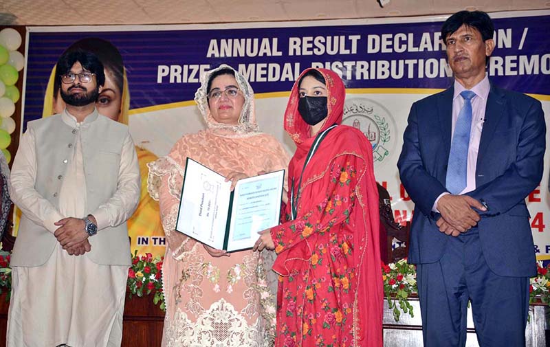 Divisional Commissioner Madam Silwat Saeed is awarding prize and medal to position holder student of Matric (1st Annual) Examination 2024 during formal result declaration ceremony at Divisional Model School & College