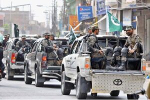 Security officials holding a flag march to develop a sense of protection among the masses and maintain law and order during the holy month of Muharram