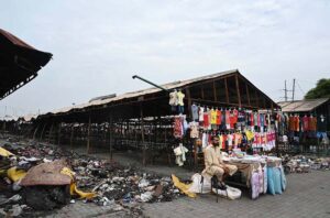 A vendor showcases children's garments at a makeshift stall amidst the debris of last week’s devastating blaze at the H-9 weekly bazaar, which destroyed 2,743 stalls and 625 shops, causing millions in damages in Federal Capital.