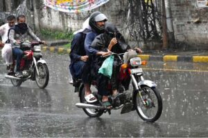 A woman holding an umbrella to protect from rain while riding on motorcycle in the Provincial Capital