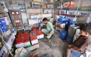 Vendor verifies UPS battery acid levels before sale at Shobha Bazar at Shobha bazar.