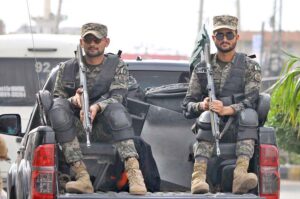 Security officials holding a flag march to develop a sense of protection among the masses and maintain law and order during the holy month of Muharram