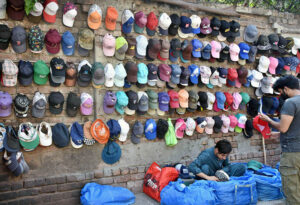 A vendor displaying and selling caps to the customers at his roadside setup in the Provincial Capital.