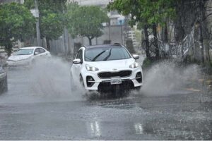 A woman holding an umbrella to protect from rain while riding on motorcycle in the Provincial Capital