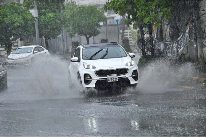 A woman holding an umbrella to protect from rain while riding on motorcycle in the Provincial Capital