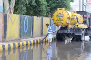 WASA staffer is busy draining the rainwater with the help of a sucker machine at old Bahawalpur Road