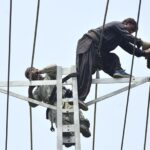 HESCO workers busy in installing new electric wire on the electric pole at Fatima Jinnah Road