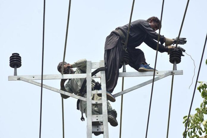 HESCO workers busy in installing new electric wire on the electric pole at Fatima Jinnah Road