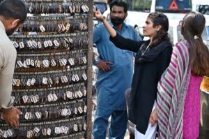 A girl selecting and purchasing keychain with her name from vendor at famous picnic spot Daman-e-Koh