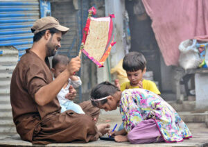 A person airing with hand fane while her daughter writing something while sitting outside their home during hot and humid weather in the city.
