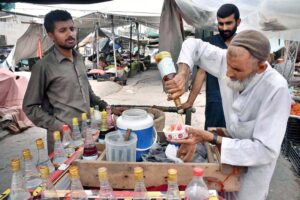 An elder vendor preparing Ice kareem kulfa and selling for customers at old sabzi mandi
