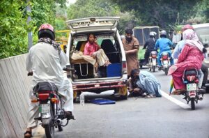 Ambulance driver busy in change the puncture tyre at Canal Road in Provincial Capital.