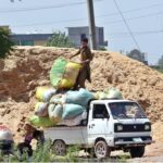 Labourers busy in loading bags of husk on Suzuki Pickup to deliver in the area at Lehtrar Road
