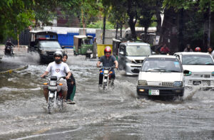 Security forces' vehicles navigate a flooded road amid heavy rain in the provincial capital.