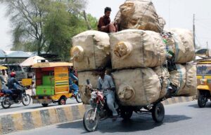 Motorcycle loader taking away empty bottles to packing point from where they would be taken to recycling factory.