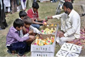 Children are buying colorful chicks from street vendor on the roadside in the city