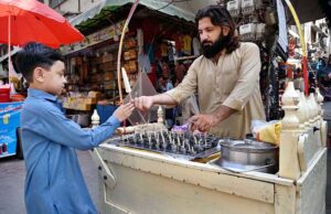 Vendor selling and displaying traditional ice cream locally called kulfi to attract the customers at Sadar bazar.