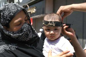 A woman with her child attending the 9th Muharram Zuljinah procession. Muharram Ul Haram is known as the first month of the Islamic calendar and the mourning month in remembrance of the martyrdom (Shahadat) of Hazrat Imam Hussain (RA), the grandson of the Holy Prophet Mohammad (PBUH).