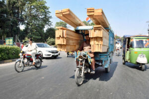A tricycle rickshaw on the way loaded with bundles of wood to deliver in Provincial Capital.