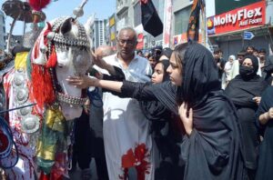 A woman with her child attending the 9th Muharram Zuljinah procession. Muharram Ul Haram is known as the first month of the Islamic calendar and the mourning month in remembrance of the martyrdom (Shahadat) of Hazrat Imam Hussain (RA), the grandson of the Holy Prophet Mohammad (PBUH).