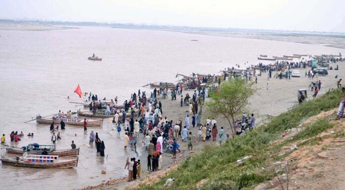 A large number of people are enjoying the cloudy weather at the Indus River