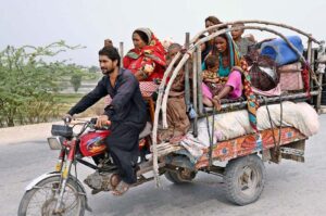 A gypsy family on their way while traveling on tricycle loader at Bypass Road.