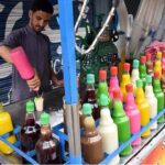 A vendor preparing ice gola for customers at his roadside setup in the Provincial Capital