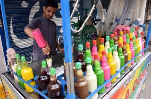 A vendor preparing ice gola for customers at his roadside setup in the Provincial Capital
