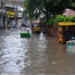 People passing through stagnant rain water after heavy rain in the city
