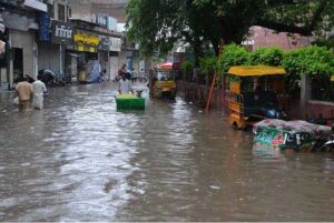 People passing through stagnant rain water after heavy rain in the city