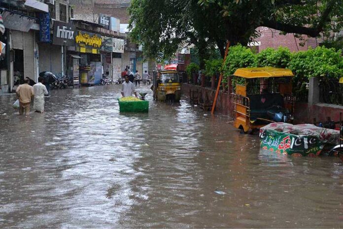 People passing through stagnant rain water after heavy rain in the city