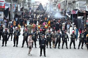 Security officials high alert in front of mourners attending the procession on 10th of Holy Month of Muharramul Harram at Station Road. Muharram is the mourning month in remembrance of the Shahadat of Hazrat Imam Hussain (RA), the Grandson of the Holy Prophet Mohammad (PBUH).