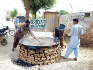 Laborers busy preparing carpeting material for the road.