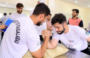 Women Sports Students lock their arms in arm wrestling while celebrating Olympic Day at the University of Faisalabad(TUF).
