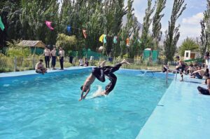 Youngsters jumping and taking bath in swimming pool to get relief from hot weather in the city