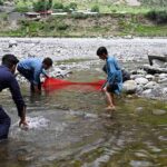 Visitors catching fishes in traditional way at Nalter river