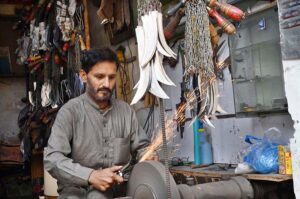 Blacksmith busy in sharpening knives to be used during the procession of Muharram at Chowk Khuda Bakhsh Road Nonaria