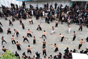 Volunteer showering water on mourners attending Youm-e-Ashura procession on 10th of Holy Month of Muharramul Harram at Station Road to keep them cool during hot and humid weather in the city.