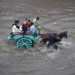 Vehicles passing through accumulated water on the road during rain in the Provincial Capital
