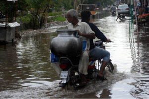 Vehicles passing through accumulated water on the road during rain in the Provincial Capital