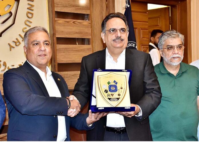 President Chamber of Commerce Abdul Ghafoor Malik presenting a shield to Pakistan Football Federation President Haroon Malik at SCCI