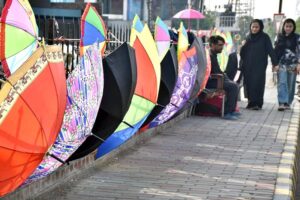 A vendor is waiting for customer amidst his colorful umbrellas on footpath in the Provincial Capital.