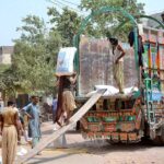 Labourers are busy loading corn sacks on a delivery truck