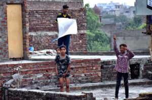 Children enjoy kite flying on the rooftop near the Do Moria Pul.