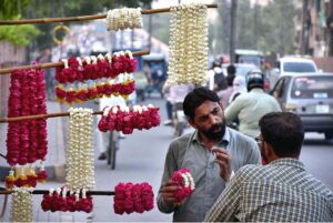 A vendor displaying and selling the flowers hands and neck garlands to the customers on the roadside in the Provincial Capital.