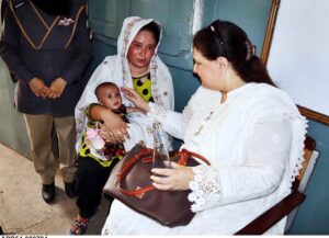 Chairperson of the Benazir Income Support Programme (BISP), Senator Rubina Khalid, interacts with a woman beneficiary during her visit to a payment campsite.