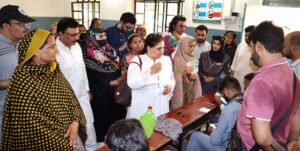 Chairperson of the Benazir Income Support Programme (BISP), Senator Rubina Khalid, interacts with a woman beneficiary during her visit to a payment campsite.