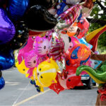 A vendor selling colorful balloons while shuttling on the road at Jinnah Super in the Federal Capital